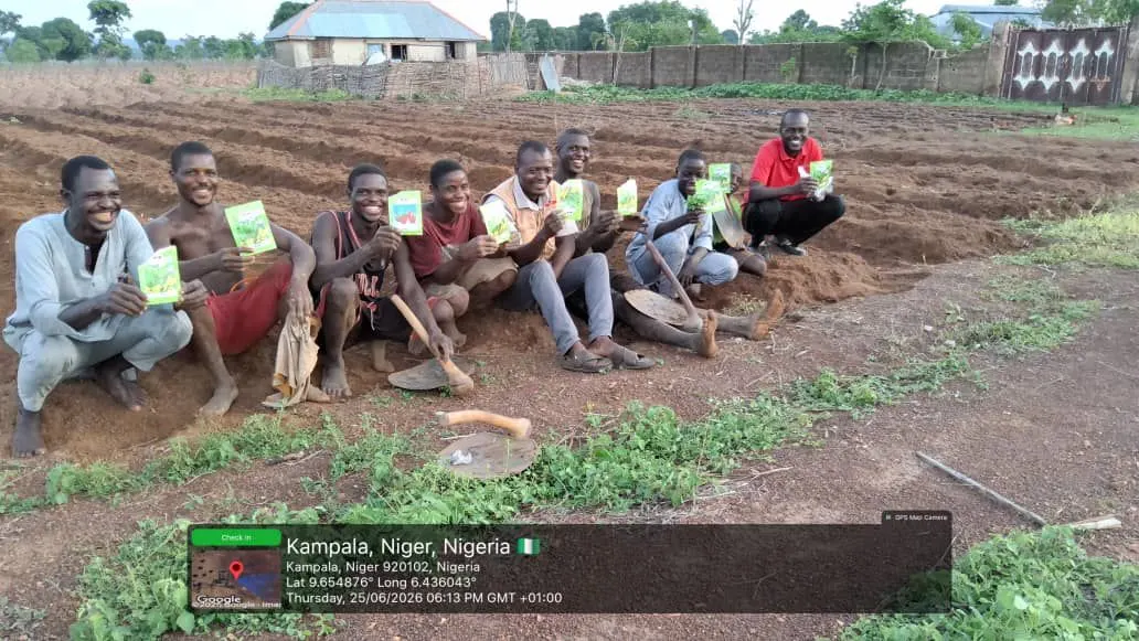 Community field team gathered beside prepared agricultural beds